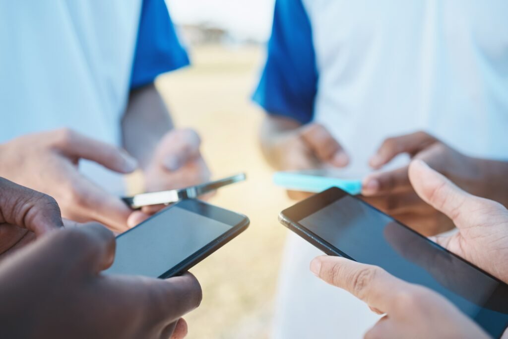 Hands, phone and networking with sports people in a huddle for communication or connectivity. Mobil